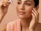 mulher com pele morena aplicando sérum clareador no rosto para tratamento de melasma